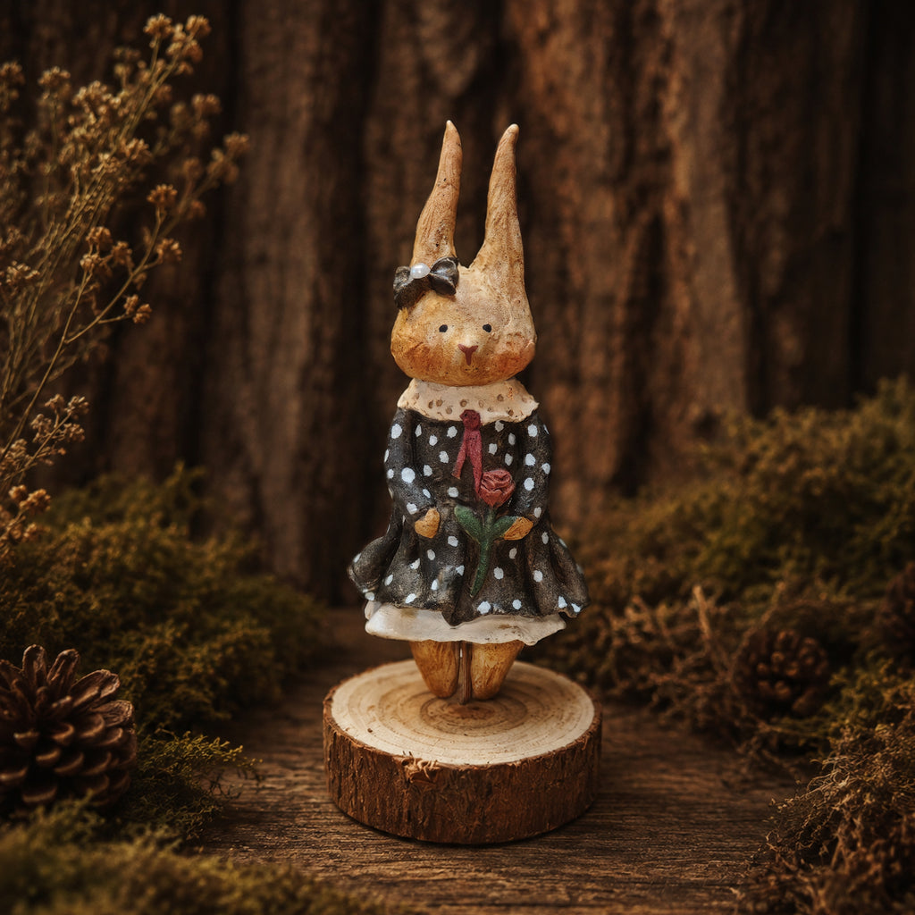 Willowwick rabbit doll in a black polka-dot dress with red details and a small black headpiece.