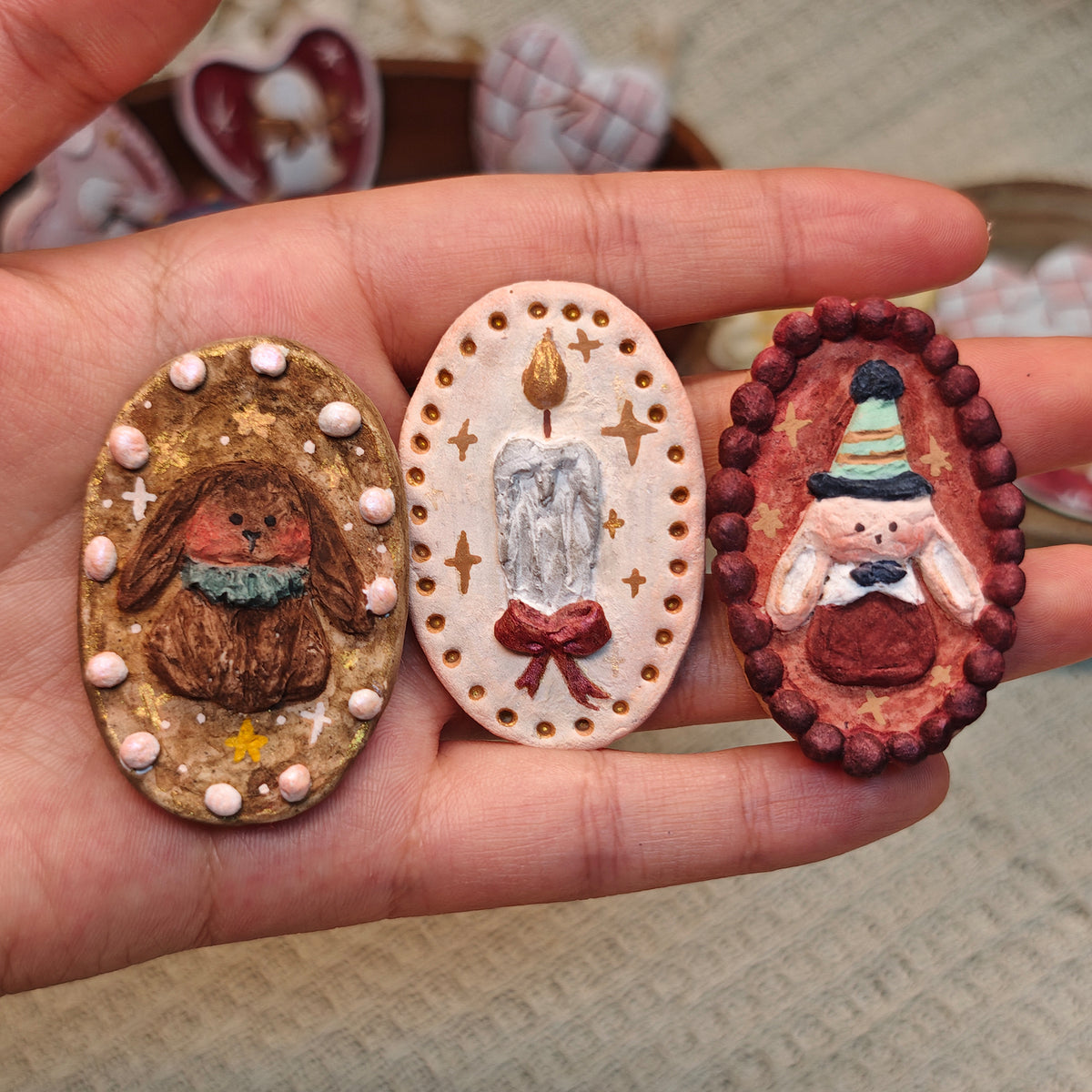 Numbered comparison of three oval Winterwood Storybook brooch designs.