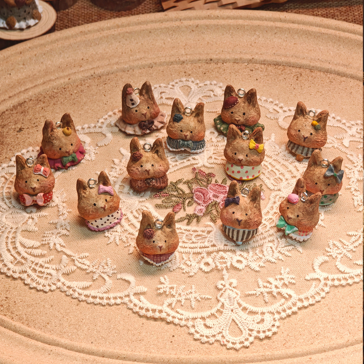 Collection of Winterwood rabbit pendants displayed on a lace-covered table.