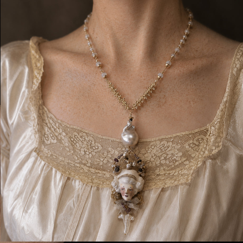 Odette Cross doll necklace worn over an ivory lace-trimmed blouse.