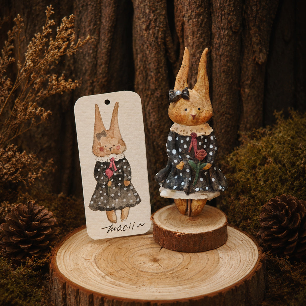 Black-dress Willowwick rabbit doll beside its matching watercolor character card.