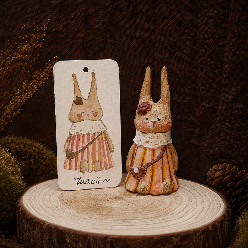 Striped-dress Willowwick rabbit doll displayed beside its matching watercolor character card.