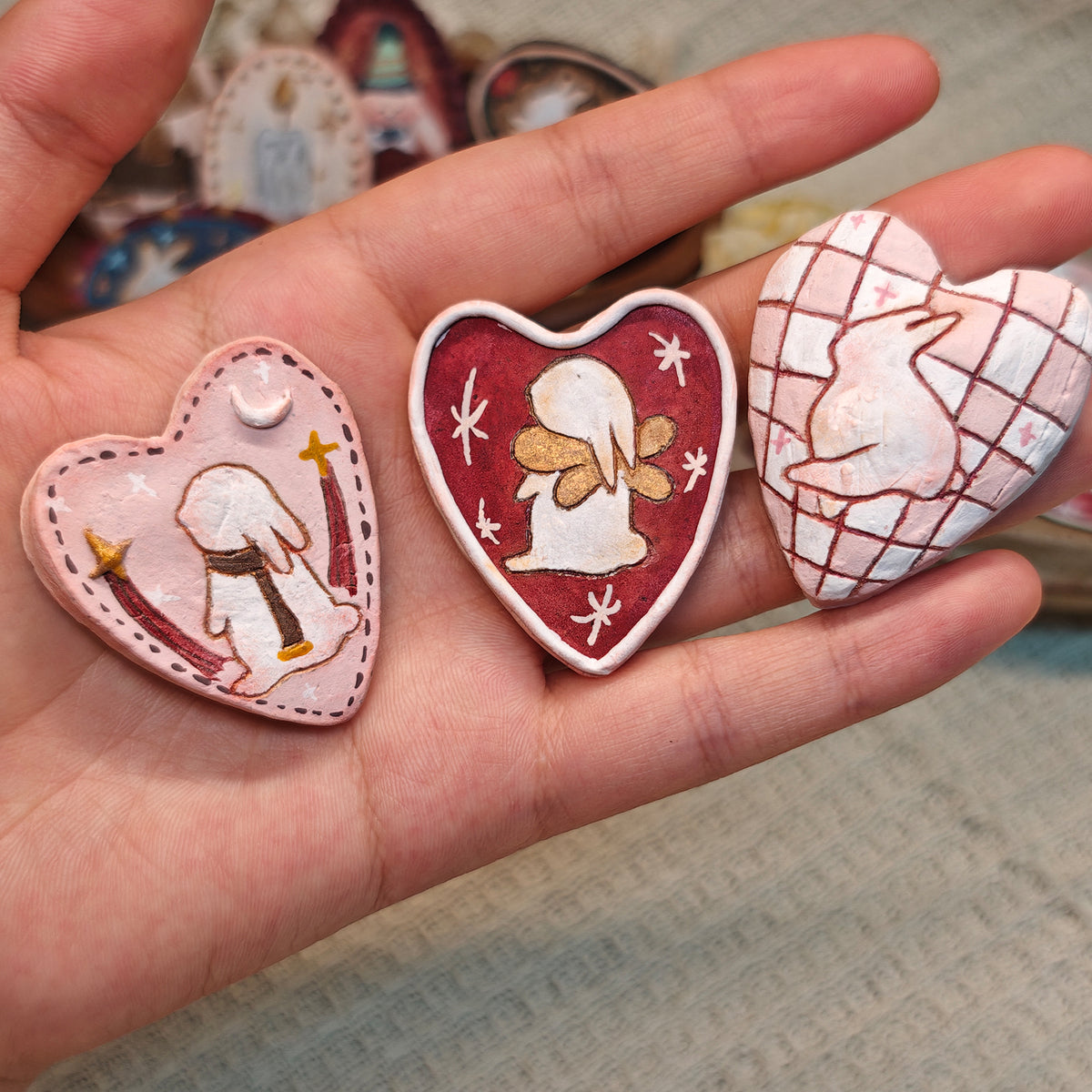 Close view of three heart-shaped Winterwood Storybook brooches.