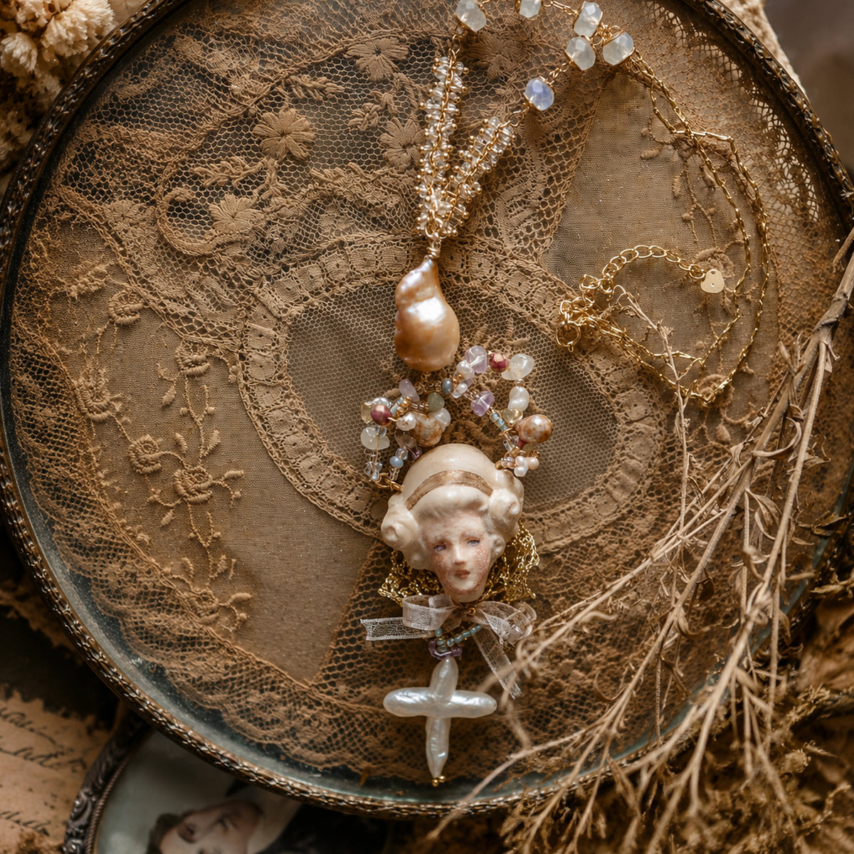 Odette Cross doll necklace arranged in a circle on brown lace.