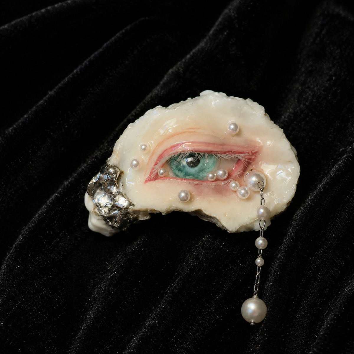Close-up of Nyra Seafoam Gaze with a green iris, pink rim and scattered pearl-like details.
