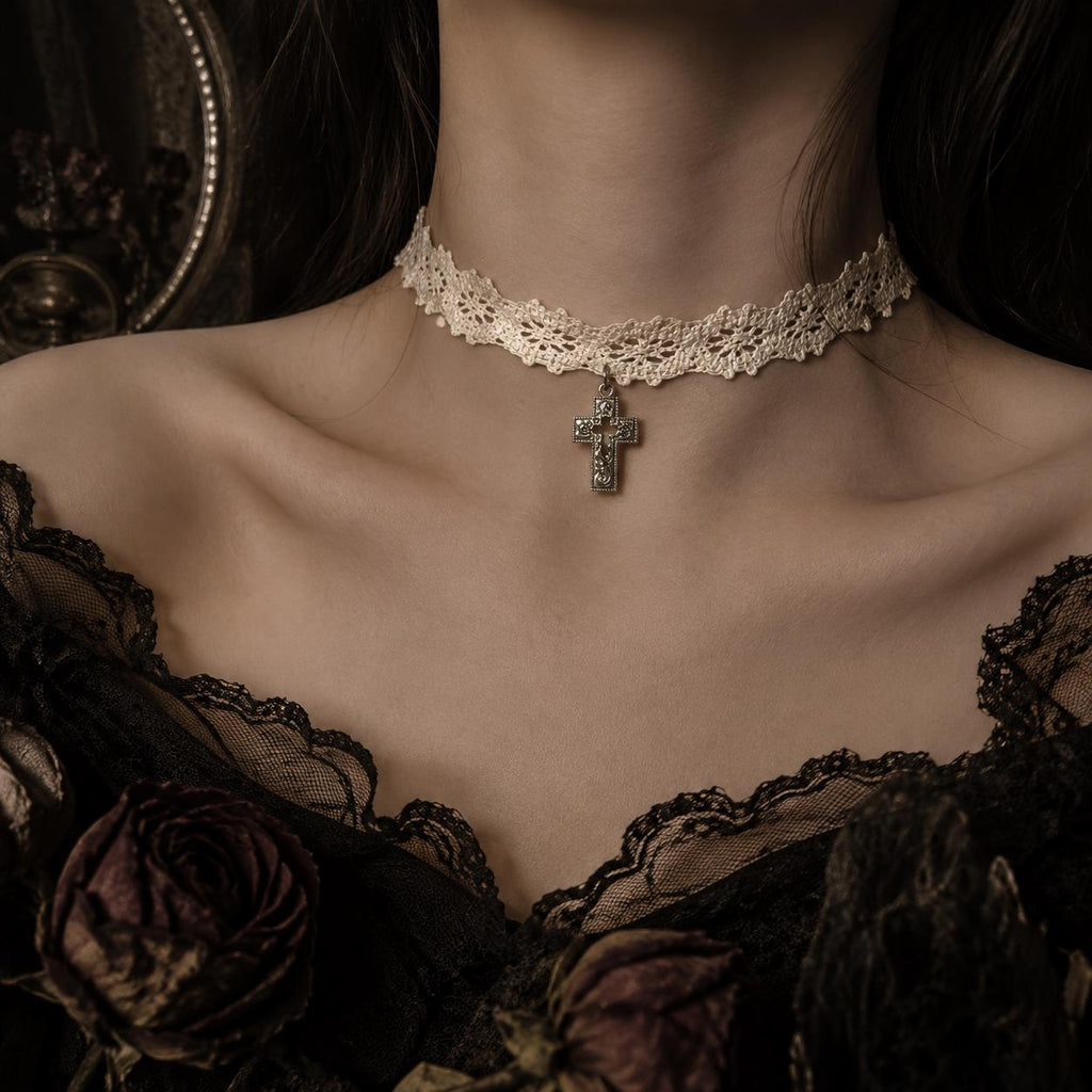 Ivory lace choker with a small cross pendant worn at the neck.
