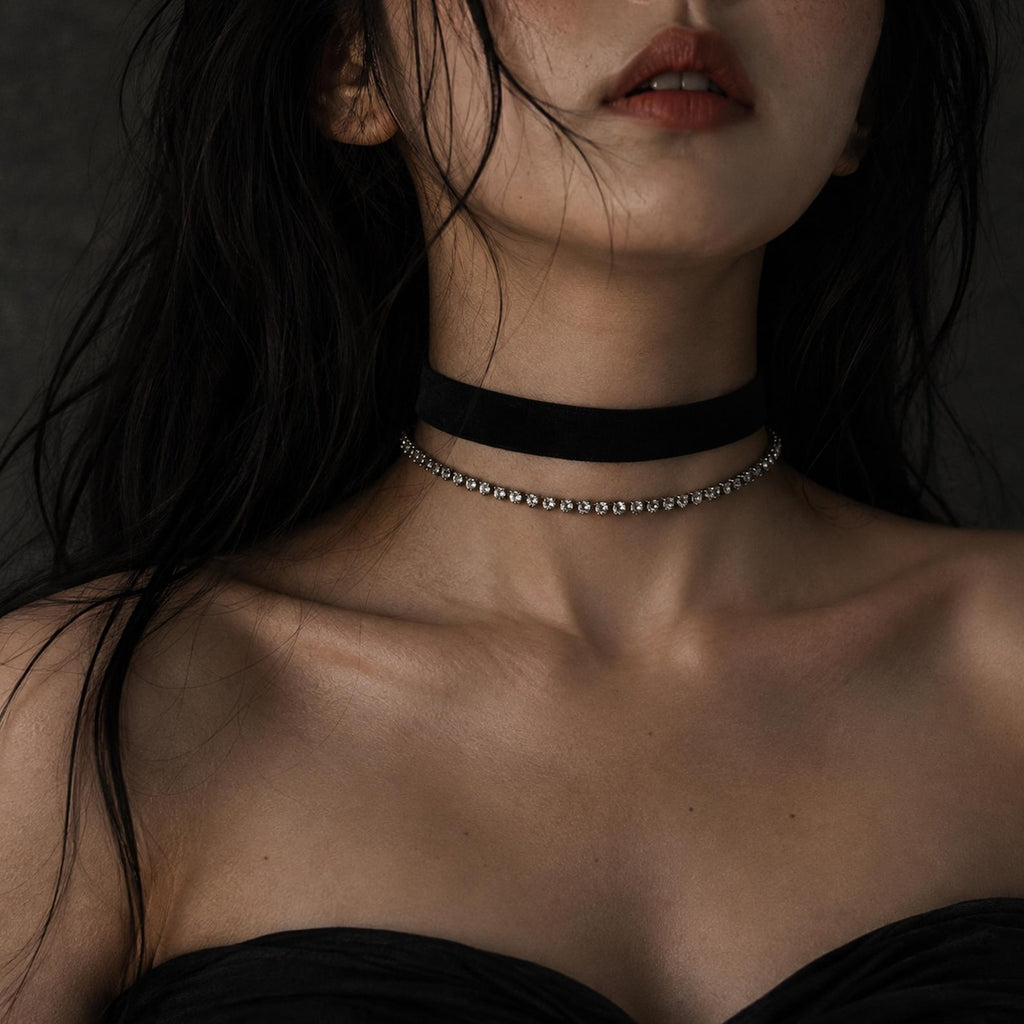 Black velvet ribbon choker layered with a separate fine silver-tone chain, shown worn.