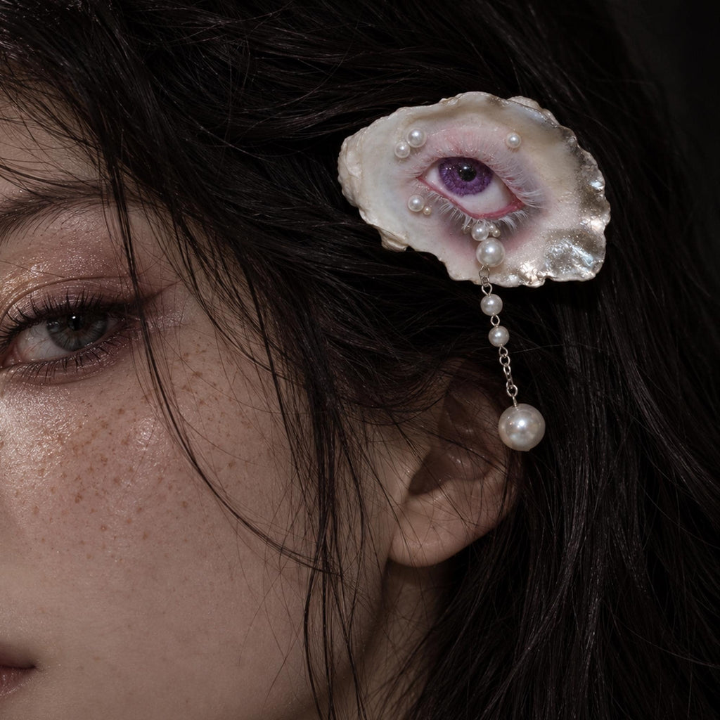 Nyra Lavender Gaze oyster-eye hair clip worn beside the temple.