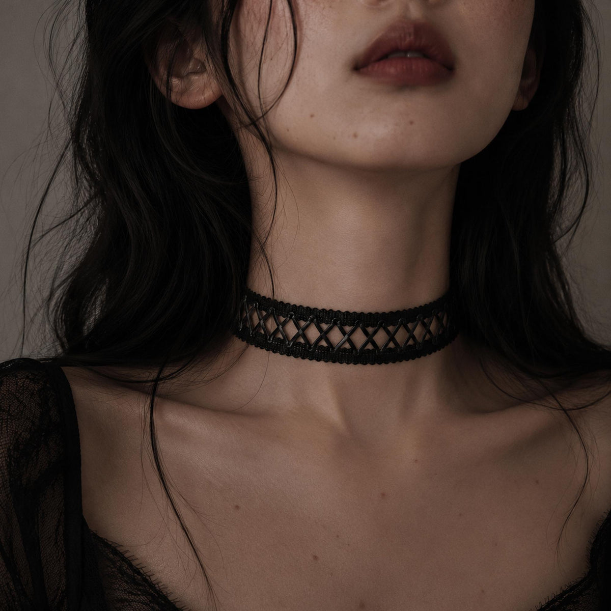 Black crisscross-lace choker worn at the neck.