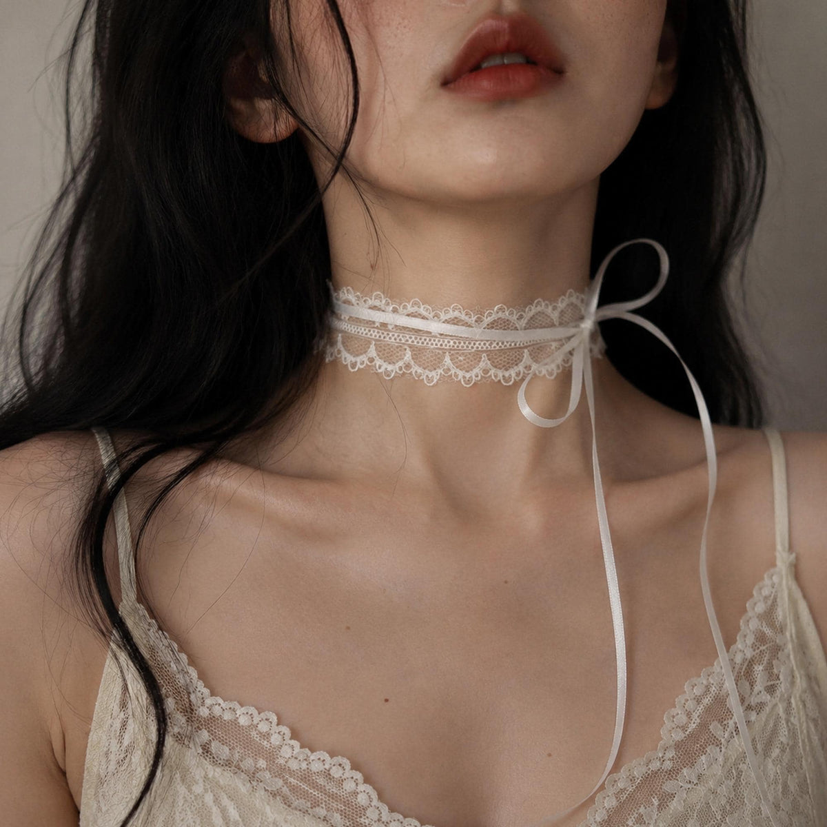 Fine white lace choker tied with a long bow, shown worn.