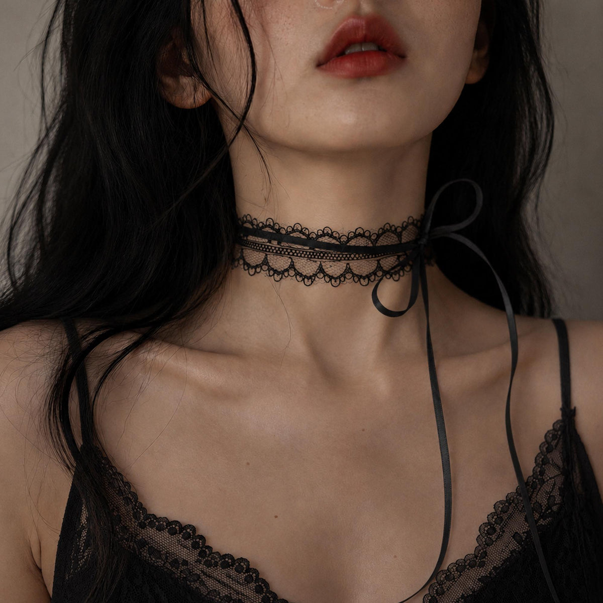 Fine black lace choker tied with a long bow, shown worn.