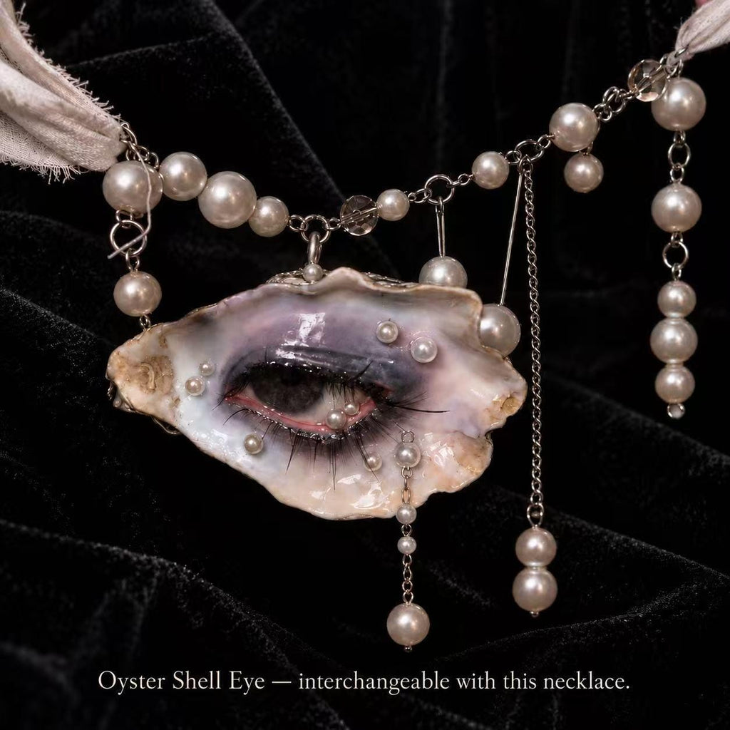 Reference necklace with a different shell-eye piece, showing the interchangeable pearl-accented attachment.