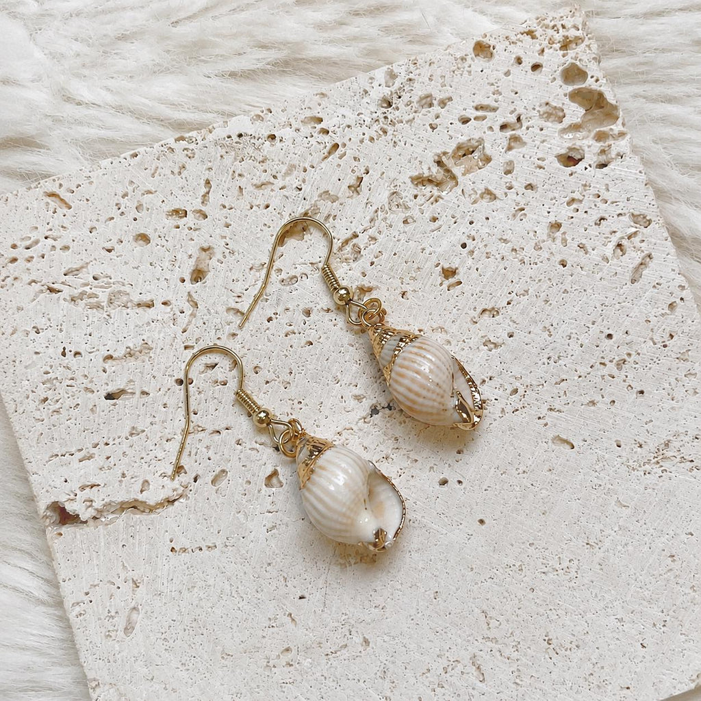 Pair of ribbed pale shell drop earrings with gold-tone caps and hooks.