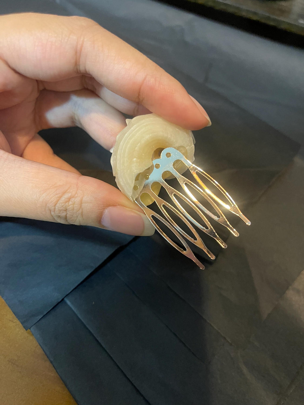 Back of a conch-shell hair comb showing its curved gold-tone teeth and shell mounting.