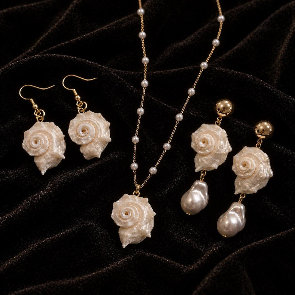 Matching conch-shell necklace and two earring styles arranged together on black velvet.