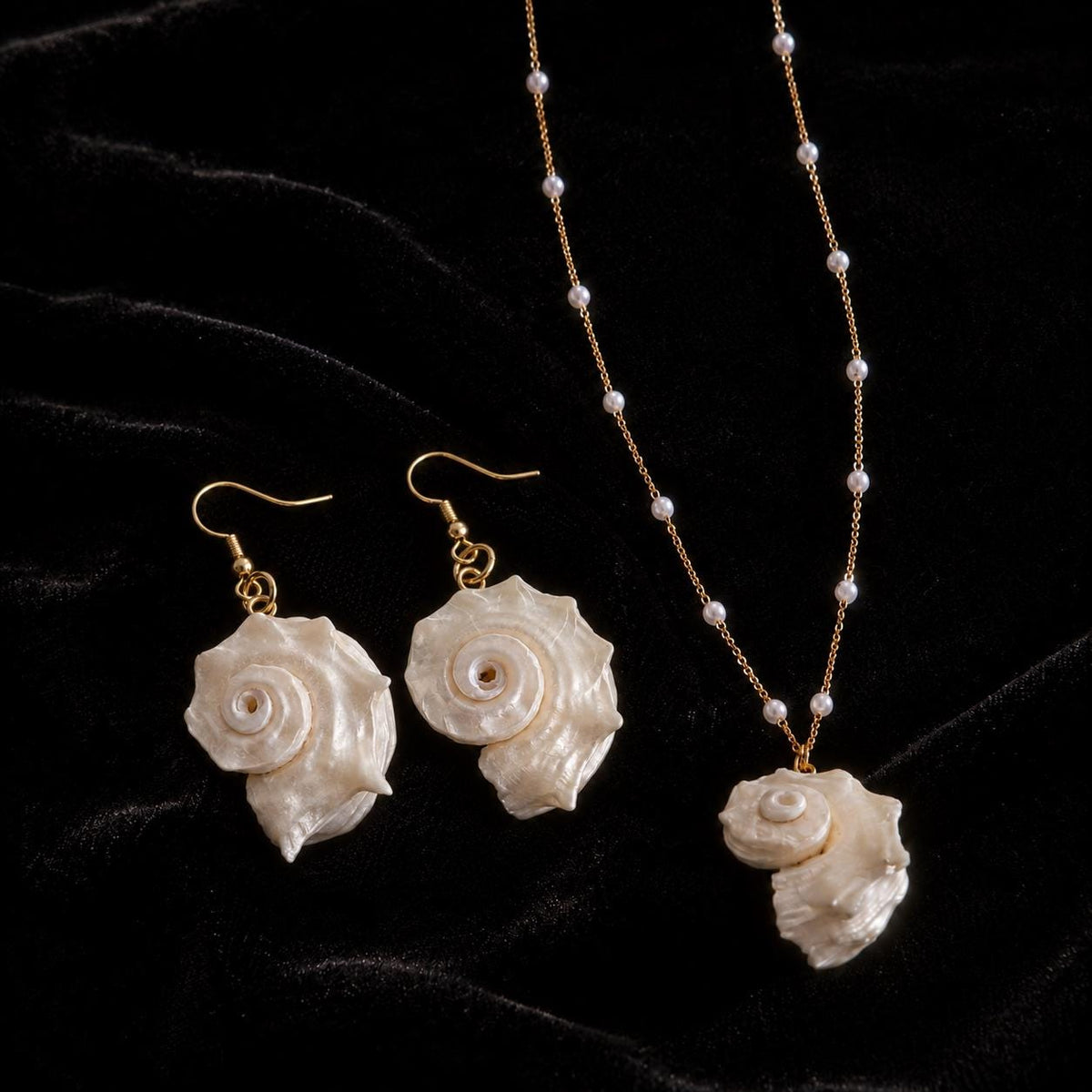 Conch-shell necklace shown with simple shell earrings and pale bead-drop earrings.