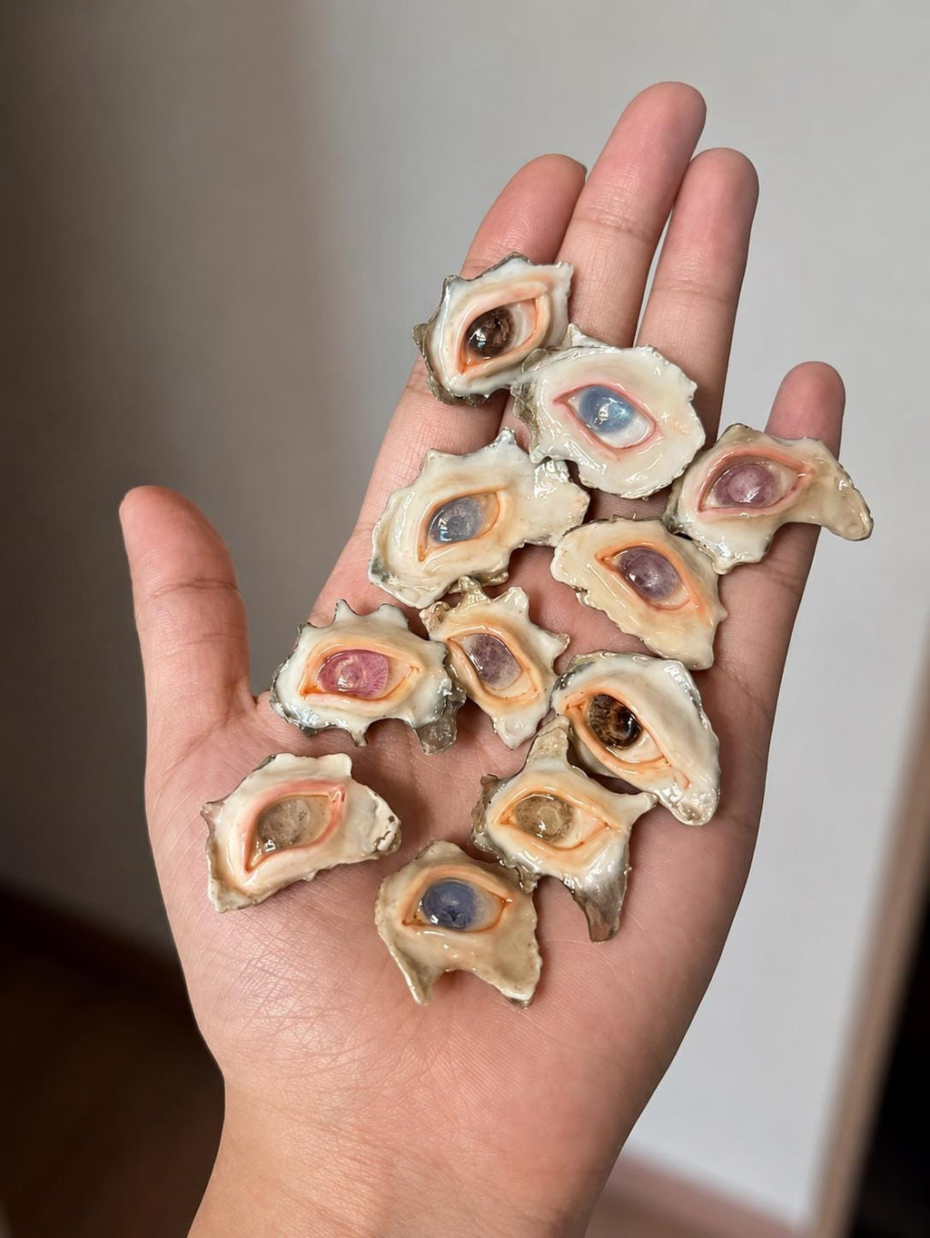 Assortment of shell-eye rings with different iris colors displayed across a palm.