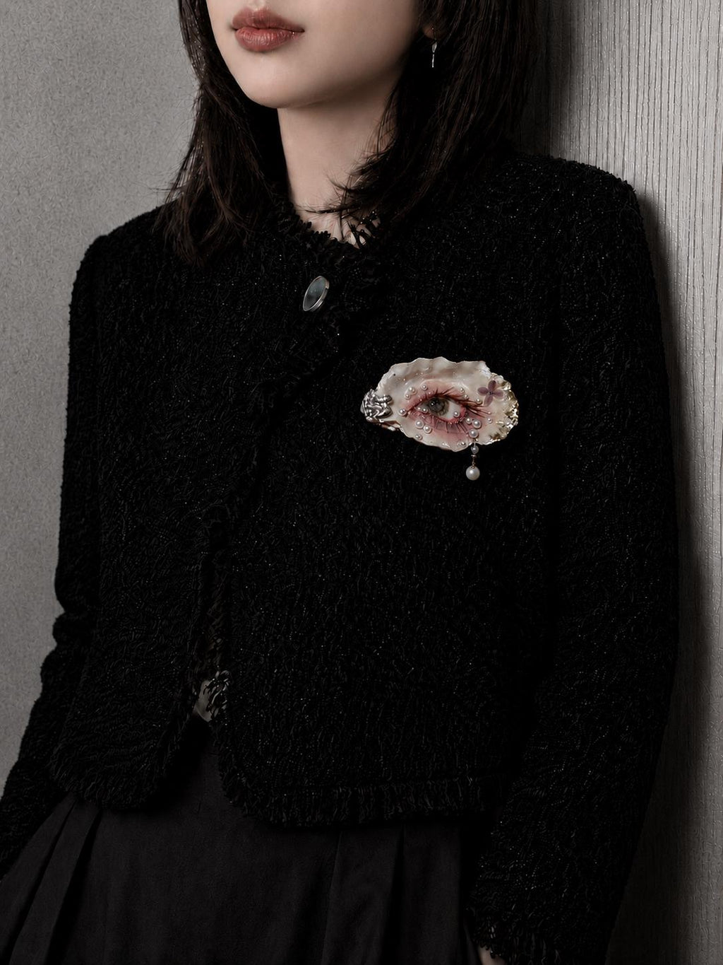 Gilded Oyster Eye brooch pinned to a black knitted top.