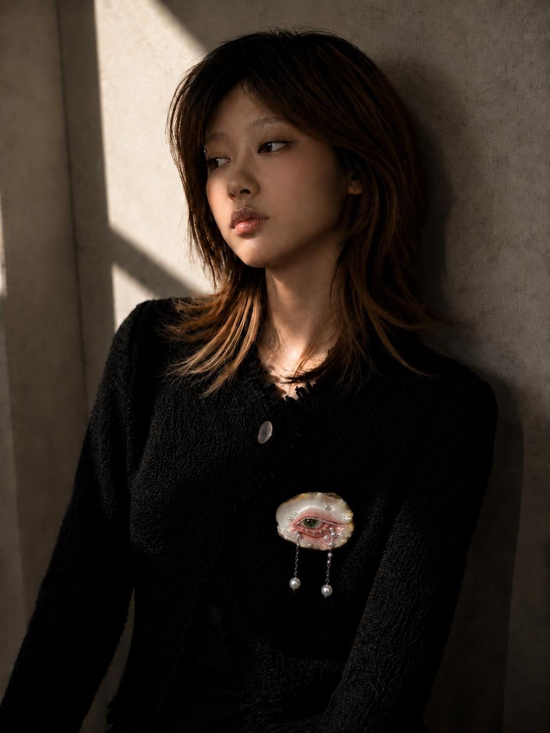 Green-and-Gold Oyster Eye brooch worn on a black knitted top.