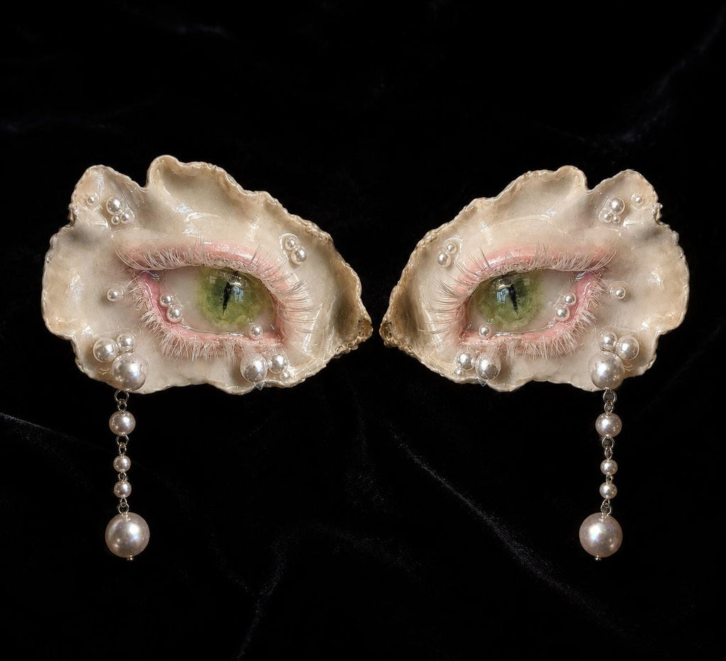 Two Cat-Eye Green Pupil pieces in different sizes arranged on black velvet.