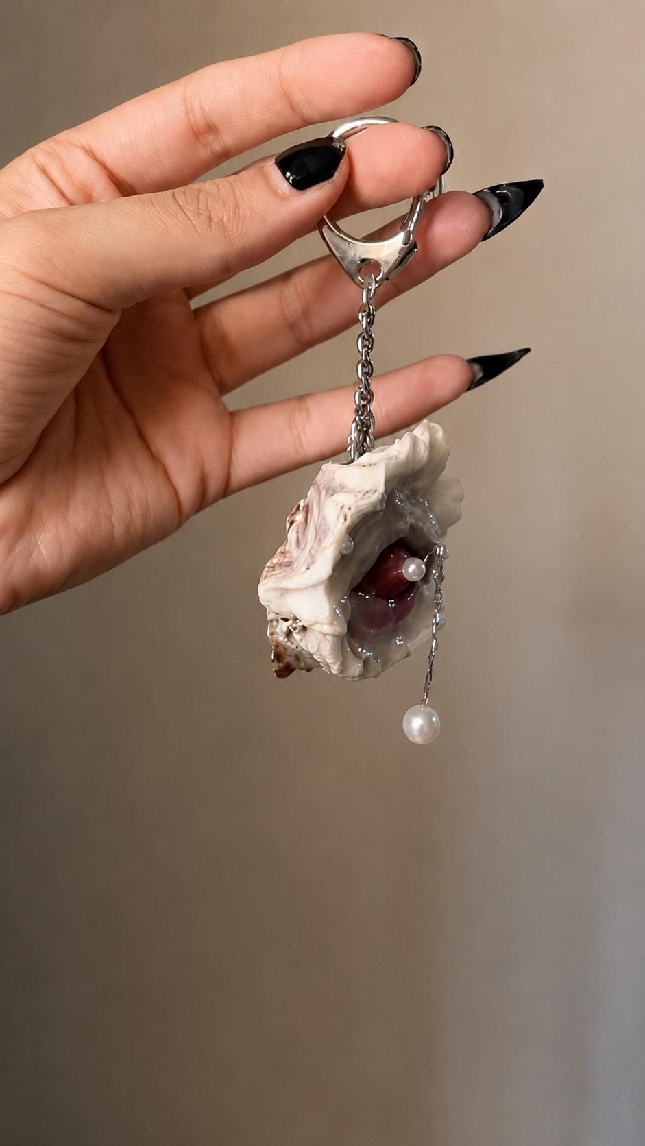 Side view of the Shell Mouth Relic keychain held in a hand.