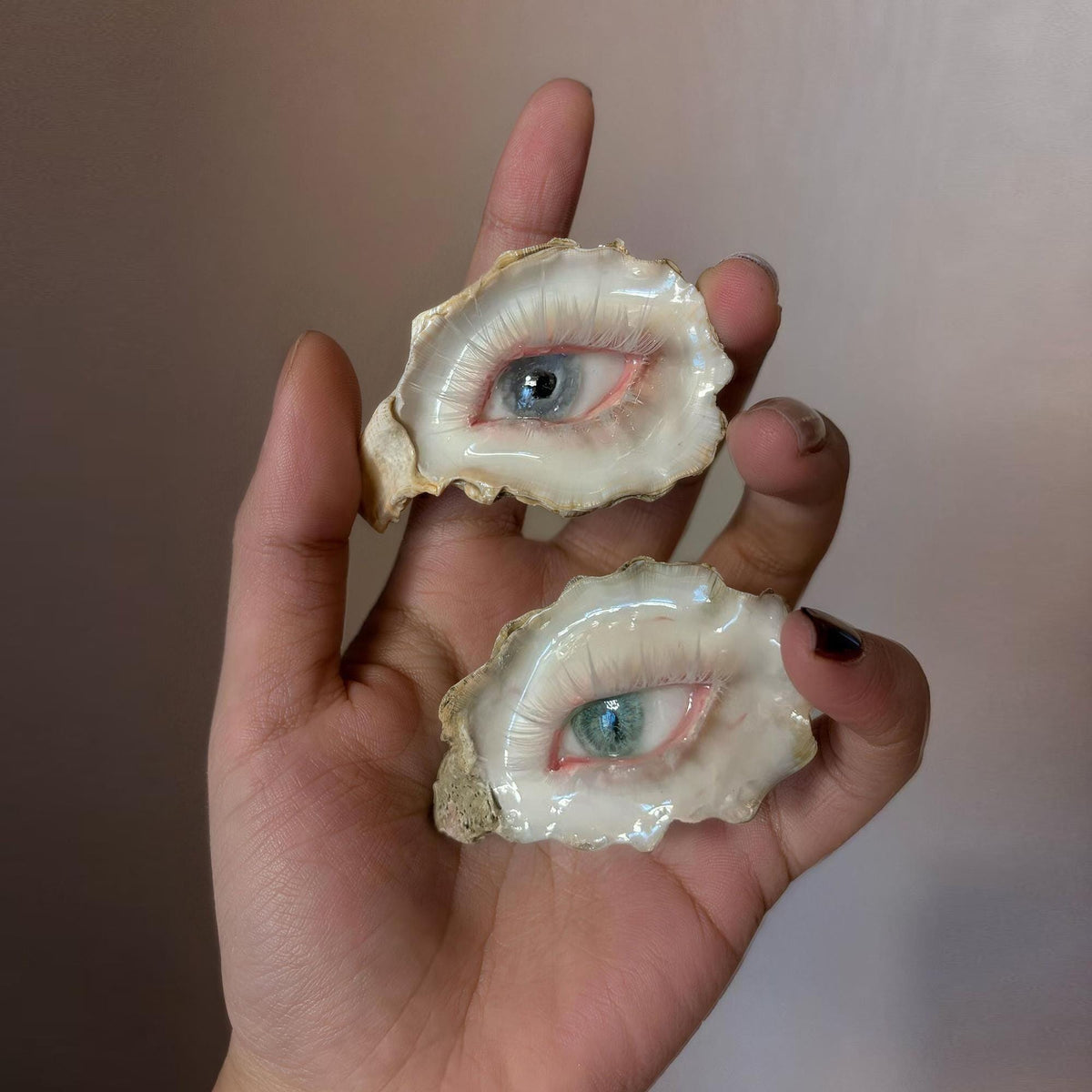 Two Pearl-Free White-Water Blue Oyster Eye pieces shown together across a hand.