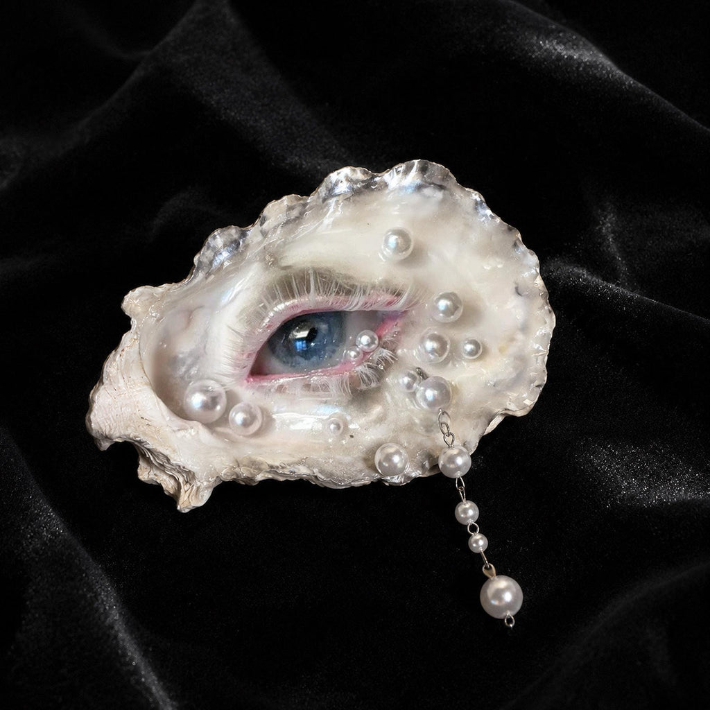Pearl-Drop White-Water Blue Oyster Eye with a blue iris and pearl-like accents on black velvet.