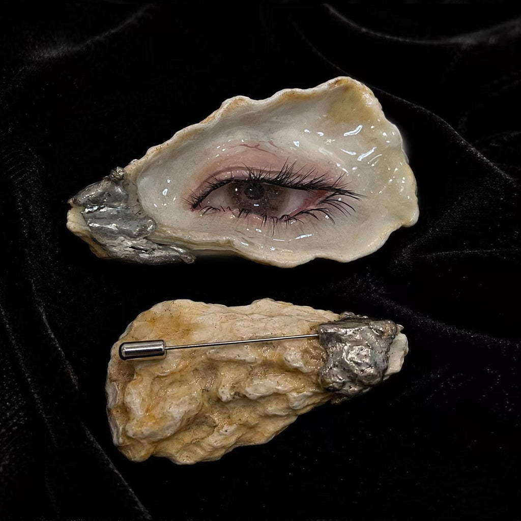 Nyra Black-Lash Oyster Eye shown with a reverse shell view and brooch pin.