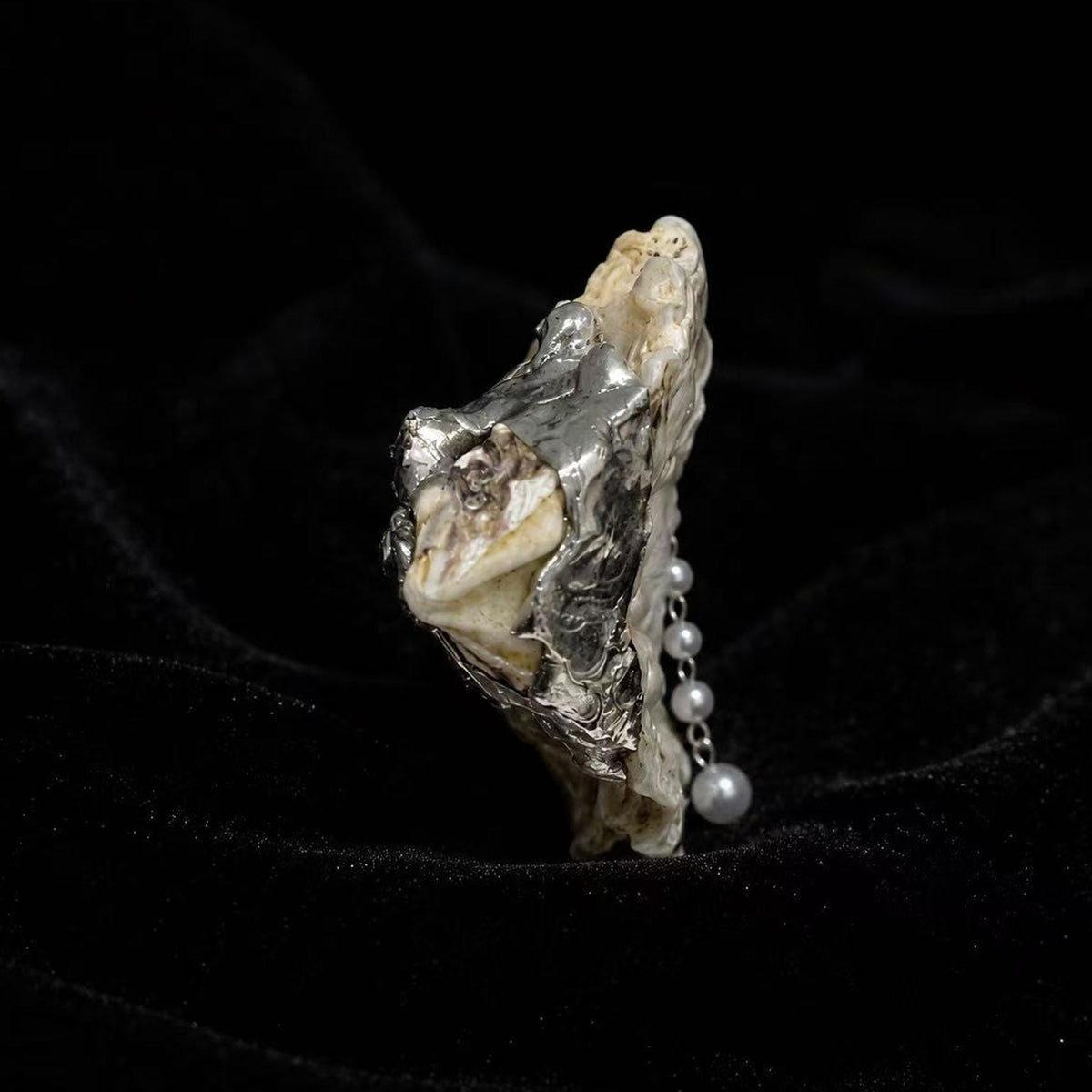 Side profile of Nyra Unimpressed Gaze showing the shell edge and hanging pearl-like drop.