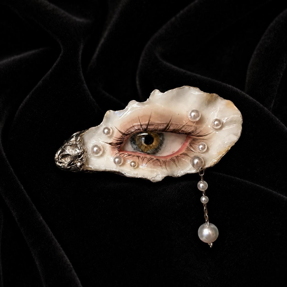 Nyra Halo Brown Eye with long dark lashes and pale pearl-like accents on black velvet.