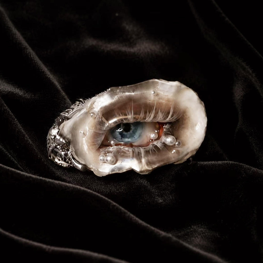 Lilith Veil Smoky Blue oyster eye with a blue iris, smoky eyelid and pale lashes on black velvet.