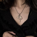 Nyra shell-eye necklace worn on a fine metal chain over a black lace top.